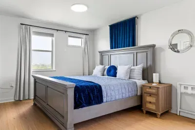 Unwind in the serene master bedroom, where a plush king-sized bed invites restful sleep, framed by soft natural light and calming neutral tones.