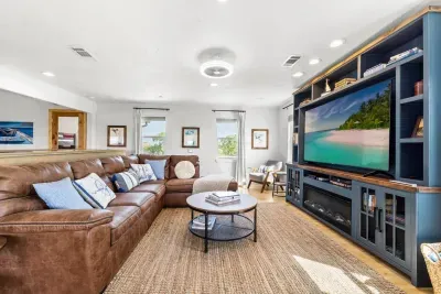 Kick back on the spacious leather couch, catch your favorite shows on the Smart TV, and unwind with sunlight streaming through the surrounding windows.