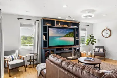 Entertainment hub! Enjoy movie night on the large Smart HDTV with Roku in a custom built-in entertainment center. Plenty of cozy seating and natural light fill the room.