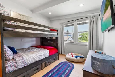 A gentle glow from the window warms this quiet space, where cozy bunk beds and thoughtful touches offer a comfortable place to rest and recharge.