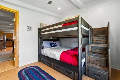 A gentle glow from the window warms this quiet space, where cozy bunk beds and thoughtful touches offer a comfortable place to rest and recharge.