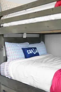 A gentle glow from the window warms this quiet space, where cozy bunk beds and thoughtful touches offer a comfortable place to rest and recharge.