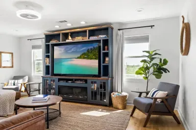 Entertainment hub! Enjoy movie night on the large Smart HDTV with Roku in a custom built-in entertainment center. Plenty of cozy seating and natural light fill the room.