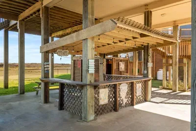 Enjoy the ultimate outdoor hangout with a covered tiki-style bar, string lights, and plenty of space to gather—perfect for grilling, games, and relaxing after a day on the beach.
