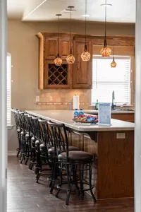 Spacious kitchen island with plenty of bar seating—perfect for family breakfasts, game nights, or gathering for snacks, all under warm pendant lighting in a bright, open-concept space.