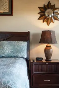 Cozy coastal bedroom details with soft bedding, warm bedside lighting, and charming decor—perfect for relaxing and recharging after a day at the beach.