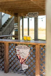 Cheers to vacation mode!  Grab a cold drink and hang out at the covered beach bar with fun coastal vibes and string lights—perfect for relaxing after a day in the sun.