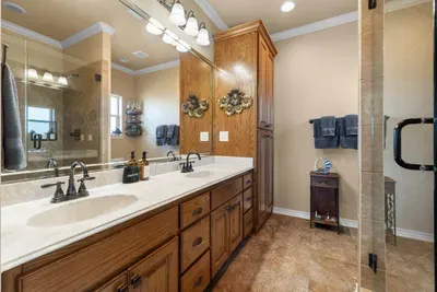 Spacious primary bathroom with a double vanity, plenty of storage, and a large walk-in shower—perfect for getting ready comfortably after a day at the beach.