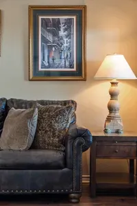 Cozy, stylish living room details with plush leather seating, warm lamp lighting, and charming coastal artwork—perfect for relaxing and unwinding in comfort.