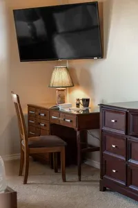 Primary suite includes a wall-mounted TV and a cozy desk/workspace—perfect for remote work, planning your beach day, or catching up on emails.