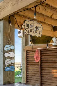 Unwind at the outdoor beach bar with string lights and a fun coastal vibe—an easy spot to relax, mix a drink, and enjoy the breeze.