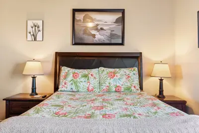 Cozy bedroom with a comfortable bed, soft linens, and warm bedside lighting—perfect for winding down after a fun day at the beach.