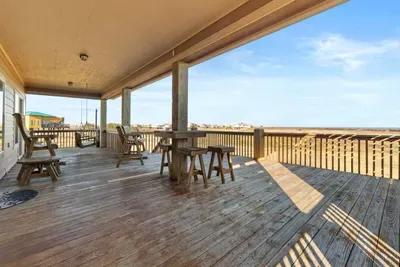 Spacious covered deck with plenty of seating and wide-open Gulf views—an ideal spot for morning coffee, sunset drinks, and relaxing coastal breezes.