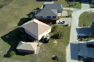 Aerial view of the home with easy beach access, plenty of parking, and a great location on a quiet coastal street.