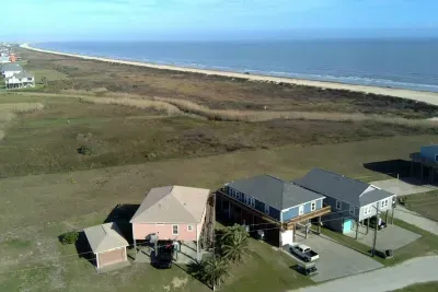 Sweeping aerial views show the home just steps from the beach, with wide open coastal scenery and quick access to the shoreline for the perfect getaway.