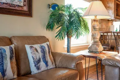Relax in this bright, beachy corner with a comfy leather sofa, coastal decor, and warm lamp lighting—perfect for curling up with a book or enjoying your morning coffee.