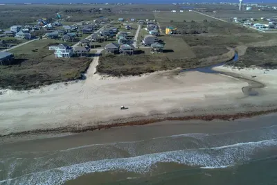 Aerial view showing the beach access and shoreline right in front of the neighborhood—easy walks to the sand, wide open space, and plenty of room to spread out.