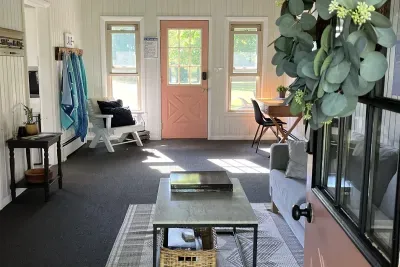 Spread out and enjoy this bonus space. The breezeway provides a cozy seating area, complete with a TV equipped with Roku, and a convenient desk positioned by the window to enjoy the beautiful lake views. 