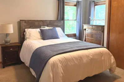 Turn in for the night! The primary bedroom located on the main floor offers a cozy bed, dresser, and even has a full bathroom attached for extra privacy and convenience! 