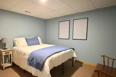 Located on the lower level this bedroom offers a queen size bed, closet, and bench. 