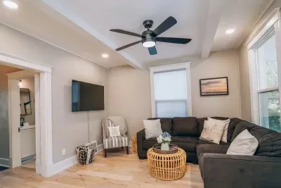 The living room features a cozy sectional couch, smart TV, and board games. It's the perfect space for guests to relax and enjoy each other's company.  