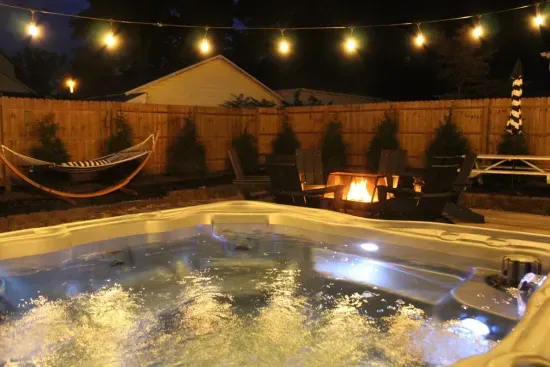 Picture your evenings in the magical backyard. With glowing edison lights, a year-round hot tub, perfect picnic space, ample seating, fire pit, gas grill, and relaxing hammock, it is sure to be a place you'll want to gather. 