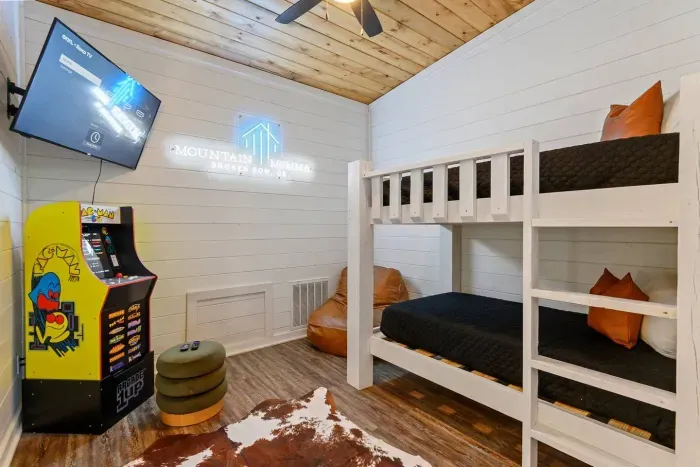 [Upstairs Loft] Twin tempurpedic bunk beds with premium linens, Pac-Man game system, 50" TV, leather chair, and custom made 'Mountain Momma' neon sign 