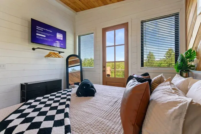 [Upstairs Master] Closet w/hangers, dresser, Smart TV, and access to private balcony