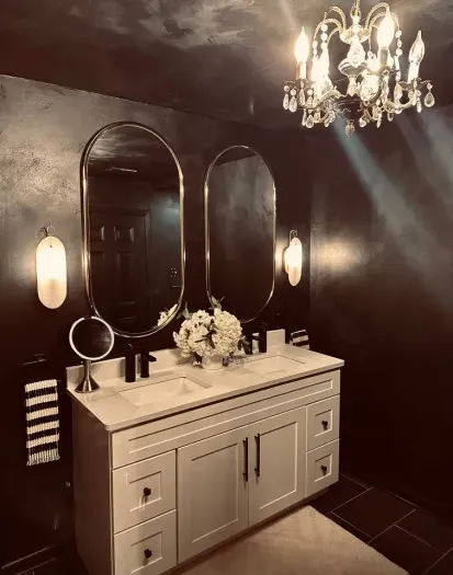 Light diffusing sconces and a vintage chandelier give this bathroom a little something extra.