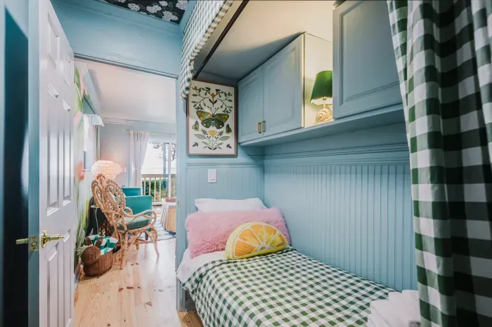 Cozy built-in twin nook with cheerful cottage style and balcony access