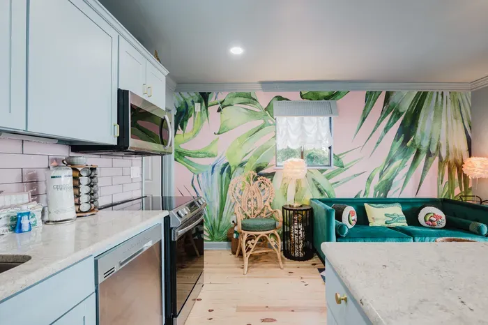 Stylish kitchen and lounge with tropical mural and velvet seating