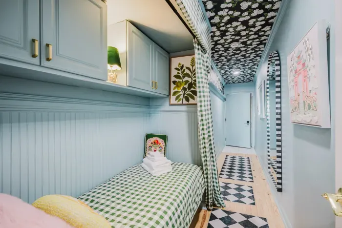 Charming built-in twin nook with bold patterns and cozy privacy curtain