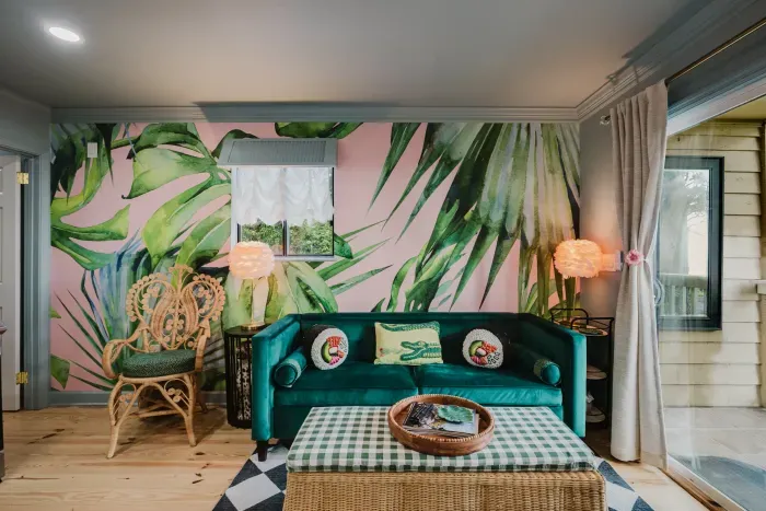 Tropical-chic lounge with velvet sofa, rattan accents, and bold mural