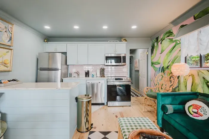 Bright designer kitchen with tropical mural and cozy lounge seating