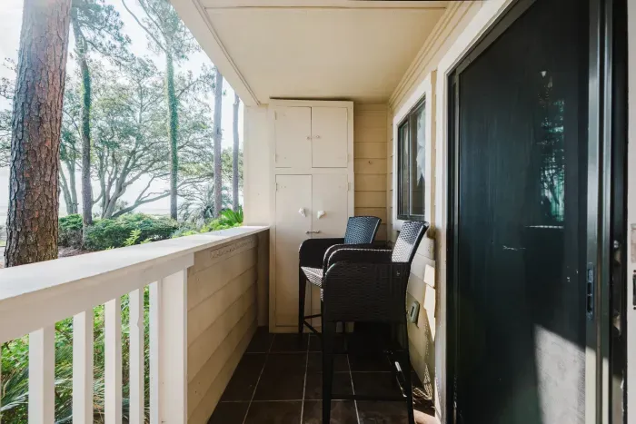 Private covered balcony with seating and serene wooded views