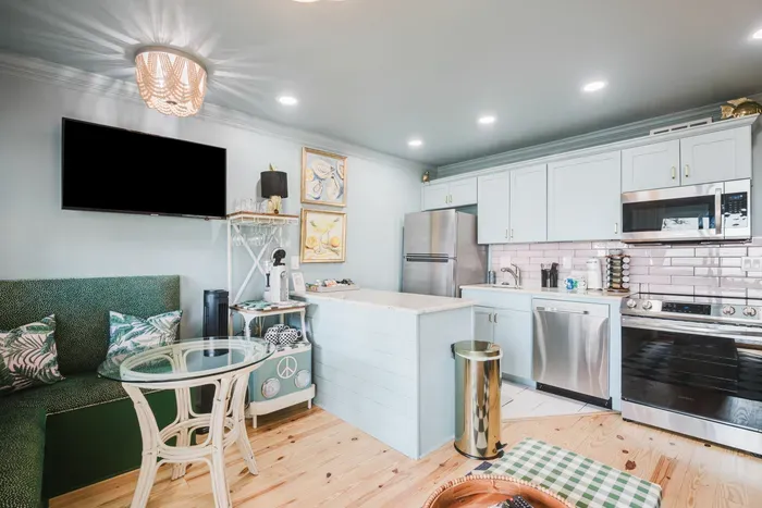 Bright coastal kitchen with island, cozy dining nook, and stainless appliances