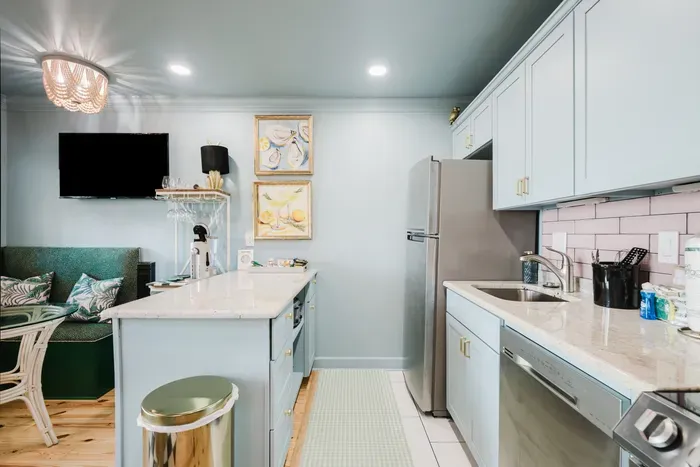 Bright designer kitchen with island, stainless appliances & cozy dining nook