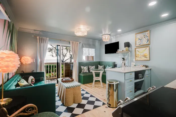 Chic lounge with banquette seating, kitchenette, and private balcony access