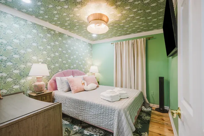 Chic botanical bedroom with plush bed, TV, and warm designer touches