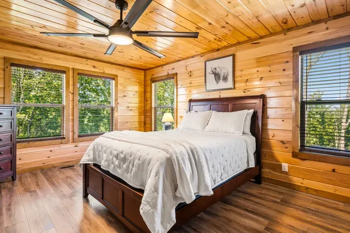 Sink into the plush queen bed and enjoy a private retreat wrapped in warm wood finishes, natural light, and serene forest views from every window.