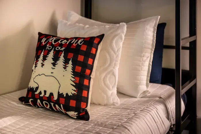 Bunk beds made up with real bedding and layered pillows. The kids get their own space — and they'll fight over the top one.