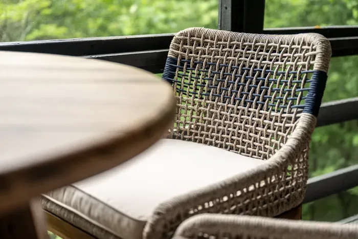 Screened porch seating for two. Coffee outside without the gnats — a Smokies non-negotiator we don't compromise on.
