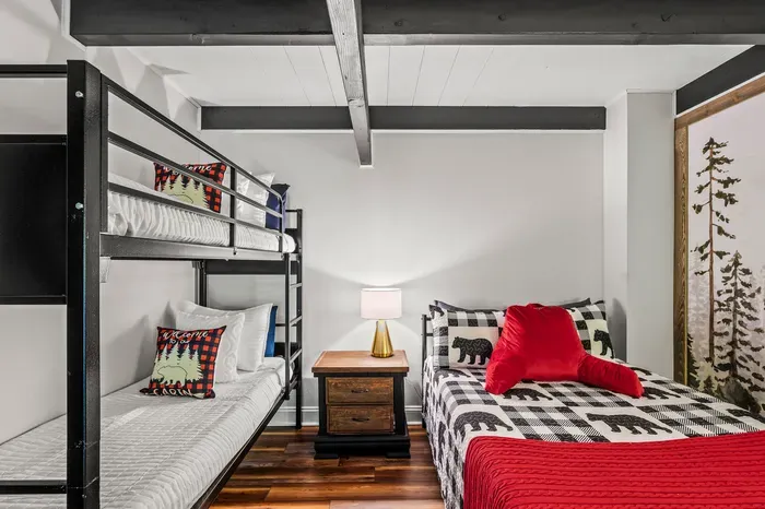 Real bedding on every bunk, a nightstand and lamp between them. Nobody's sleeping on a bare mattress here.