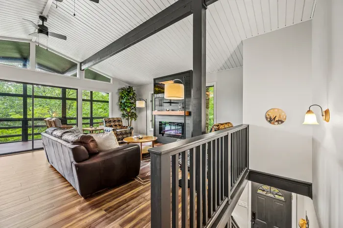 Vaulted ceilings over the whole main level, fireplace centered, front door below. You can see the entire upper floor from the landing.