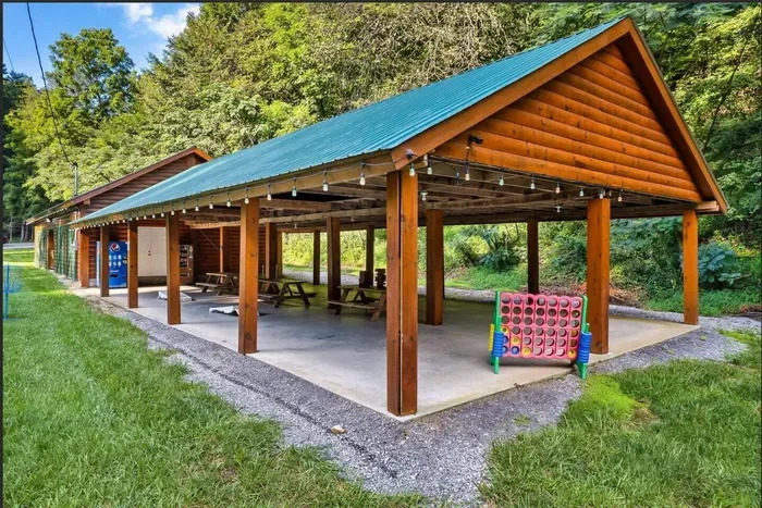 Covered pavilion with picnic tables, string lights, giant Connect Four, and vending. Good rainy-afternoon backup.