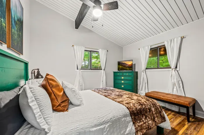 Queen bed, twin reading lamps, mountain art overhead. Simple, bright, and quiet.