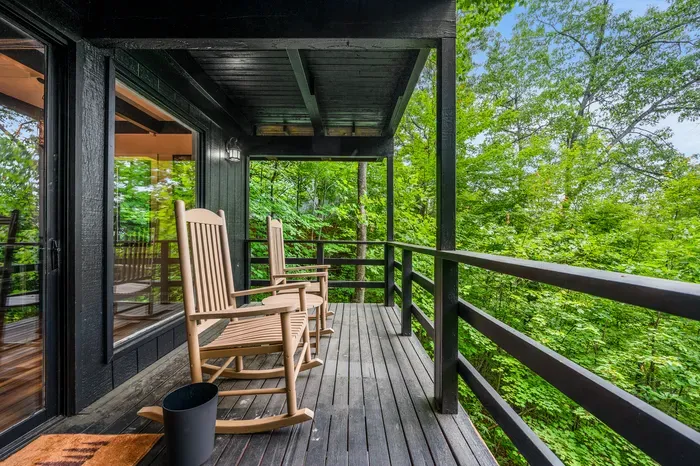 Rockers on the covered deck, hillside dropping away below. This is where the coffee happens.