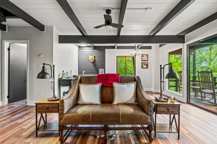 Leather sofa, matching lamps, rocking chairs waiting just past the glass. Inside and outside are about six steps apart.