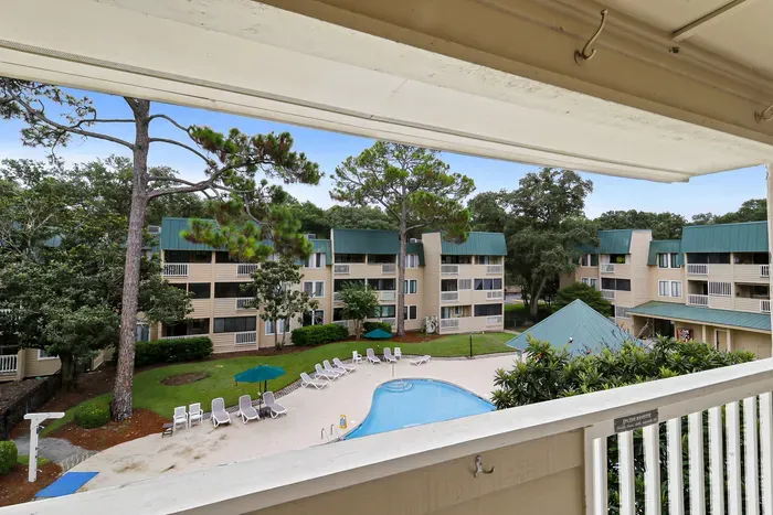 Private balcony view overlooking the pool and peaceful, tree-lined grounds