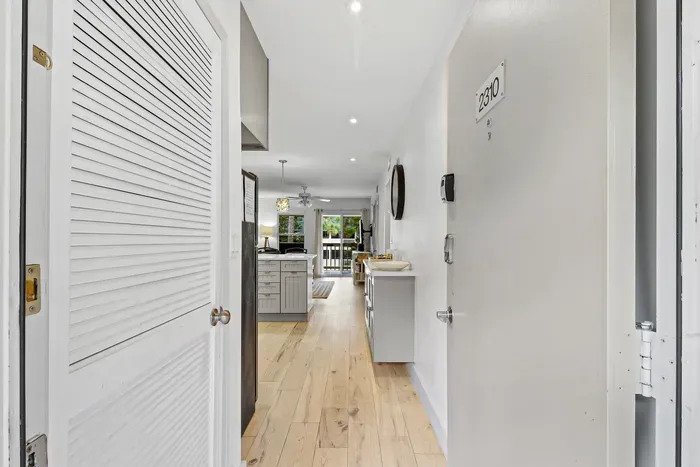 Bright modern entryway leading to an airy kitchen and balcony view